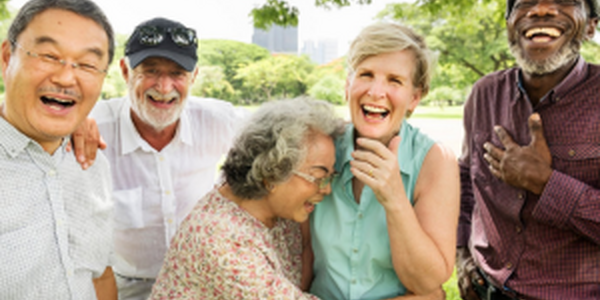 Group of happy older adults laughing outside in a park